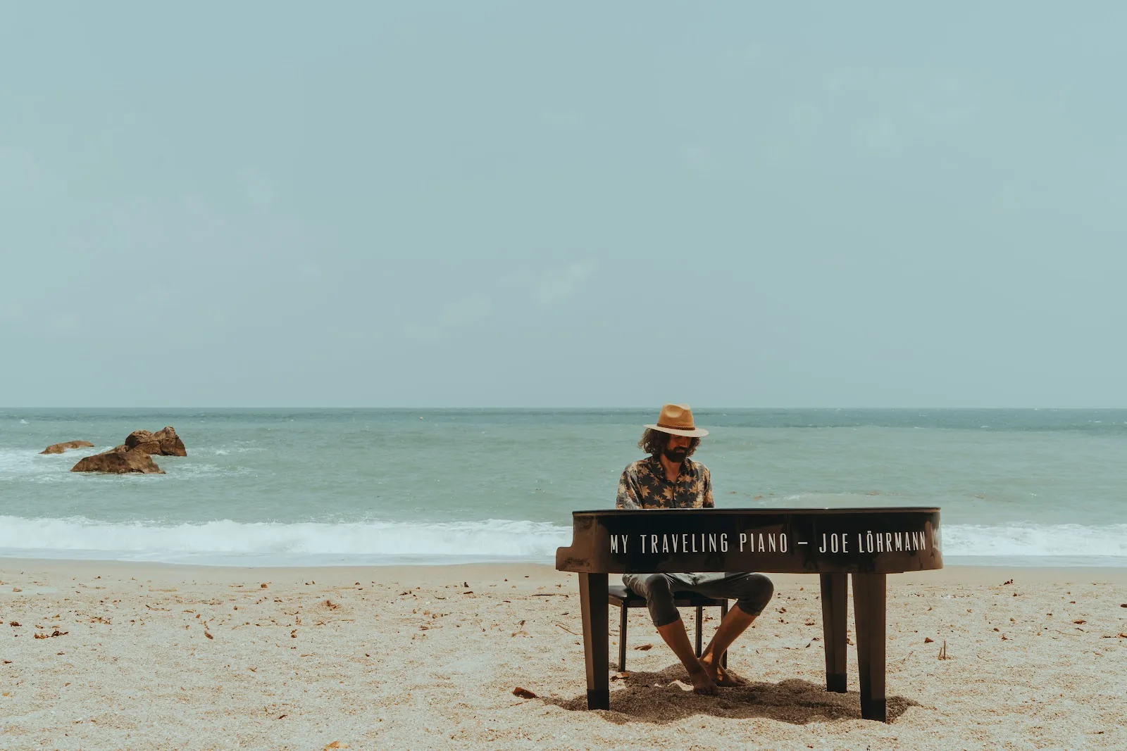 Joe Löhrmann playing piano on a tropical beach — Mother's Day Concert